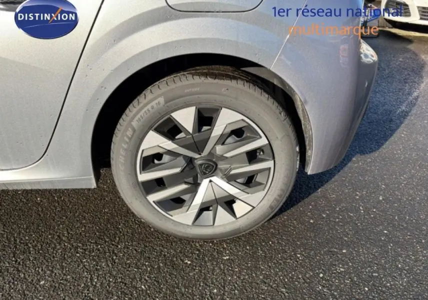 Gros plan sur la roue arrière droite grise d'une Peugeot 208 1.2 Hybrid 2025 avec jante au design géométrique.