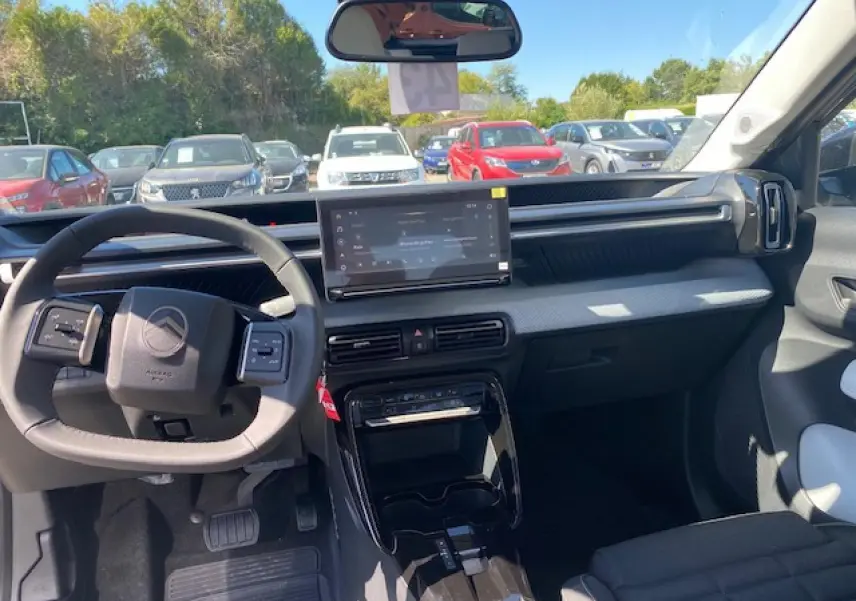 Vue intérieure avant du Citroën C3 Aircross 2026, tableau de bord gris clair avec écran tactile central et volant multifonctions.