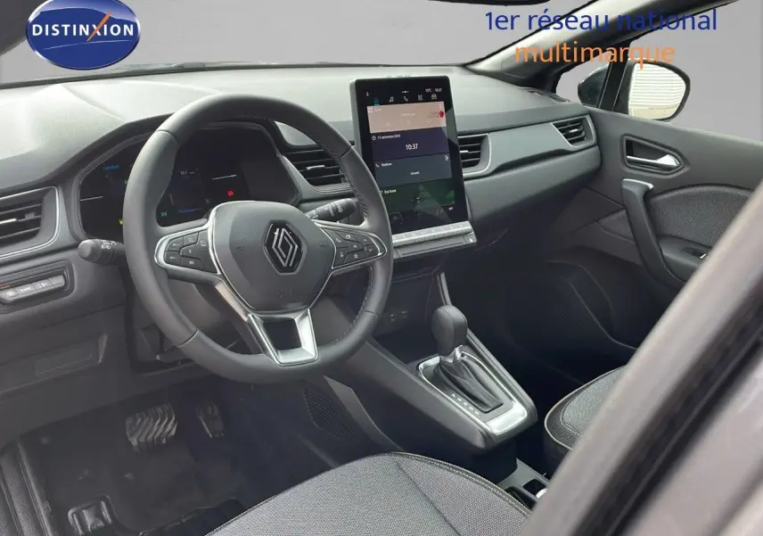 Intérieur avant droit du Renault Captur E-Tech gris cassiopée, volant multifonction et écran tactile vertical visible.