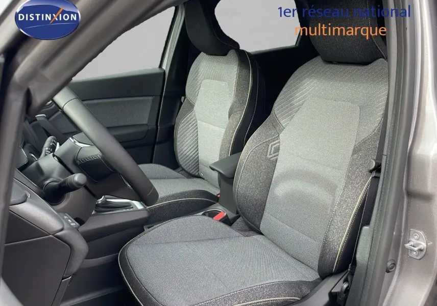 Intérieur du Renault Captur E-Tech hybride 2025, sièges avant en tissu gris avec surpiqûres contrastantes, vue côté conducteur.