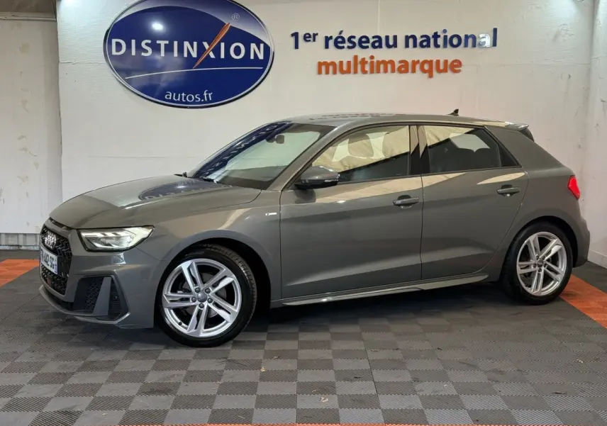 Audi A1 gris foncé vue de profil côté gauche, avec jantes alliage et logo S line sur aile avant.