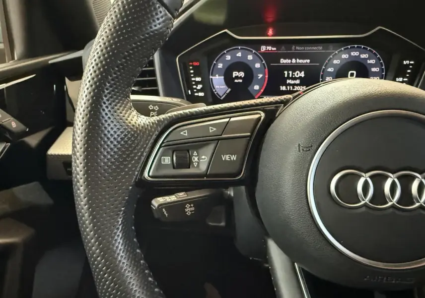 Gros plan sur le volant cuir perforé et le tableau de bord numérique de l'Audi A1 1.5 TFSI S line 2020.