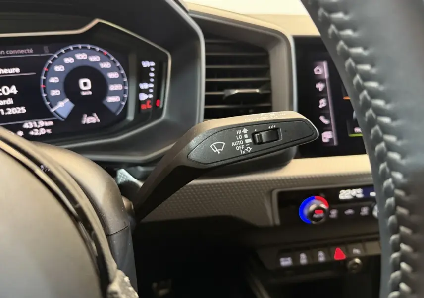 Gros plan sur la commande d’essuie-glace côté droit du tableau de bord de l’Audi A1 gris foncé, intérieur moderne.