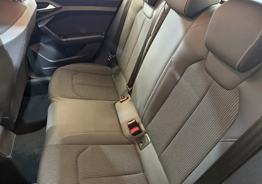Vue intérieure des sièges arrière gris foncé de l'Audi A1 2020, mettant en valeur la banquette 3 places avec ceintures de sécurité.