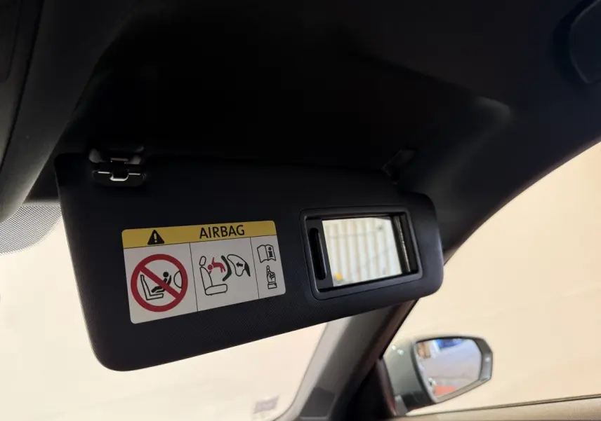 Pare-soleil côté conducteur avec miroir et avertissement airbag dans l'Audi A1 gris foncé vue de l'intérieur avant gauche.
