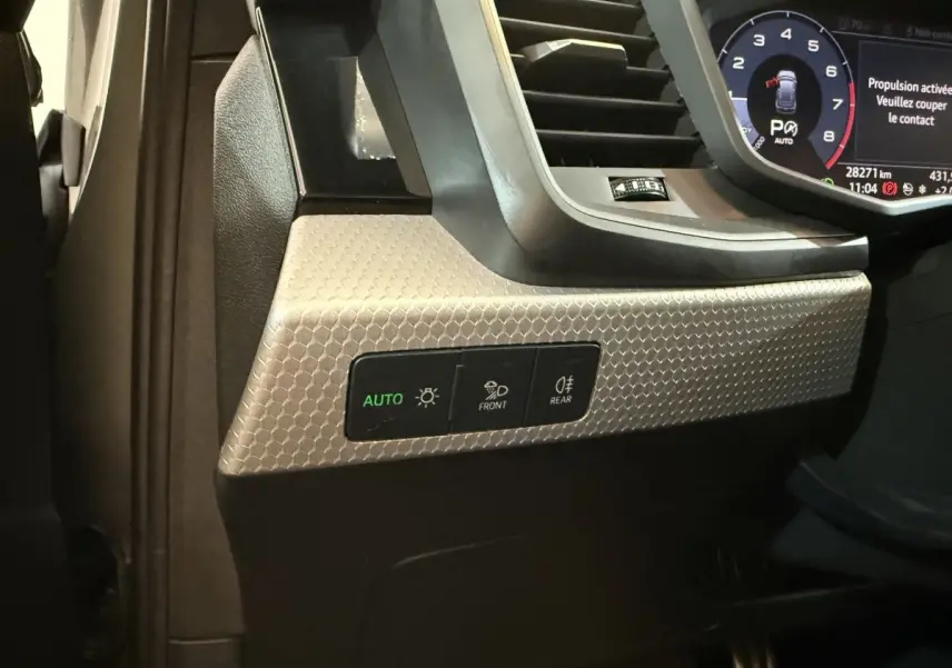 Détail du tableau de bord côté gauche de l'Audi A1 2020 avec commandes d'éclairage et finition gris texturé.