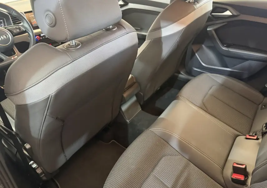 Vue intérieure arrière de l'Audi A1 2020 gris foncé, montrant les sièges en cuir et le tableau de bord partiel.