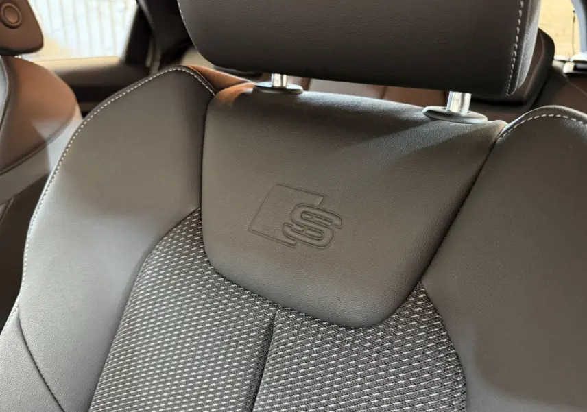 Gros plan sur le siège avant en cuir et tissu gris foncé avec logo S embossé, intérieur Audi A1 S line 2020.
