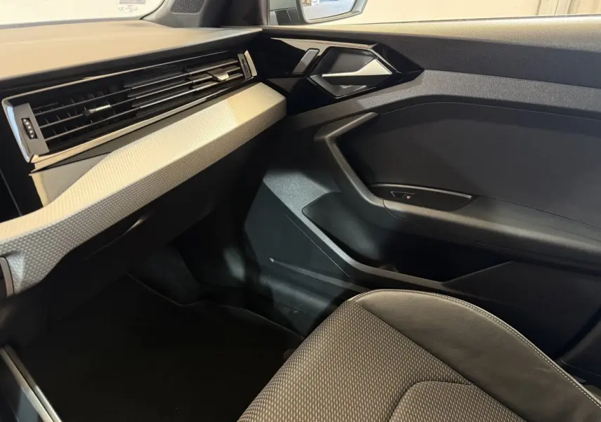 Intérieur côté passager de l'Audi A1 1.5 TFSI S line 2020 avec tableau de bord gris clair et siège tissu noir.