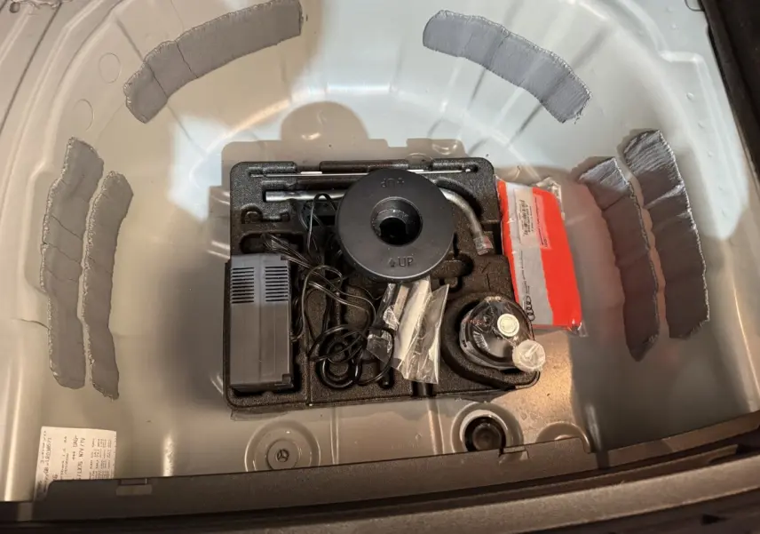 Vue plongeante sur le coffre gris clair de l'Audi A1 2020 montrant le rangement des outils et accessoires d'origine