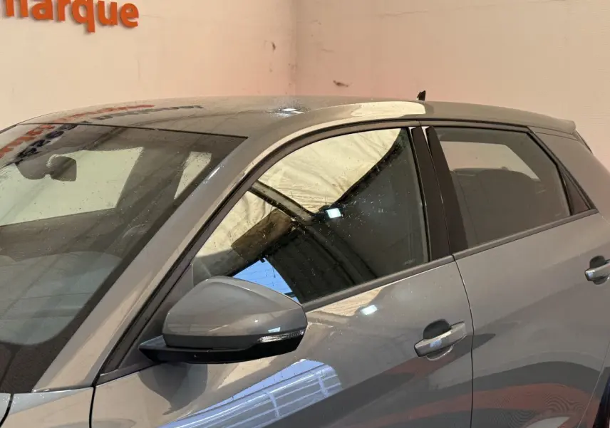 Vue latérale côté gauche d'une Audi A1 gris foncé 2020 avec rétroviseur et poignées assortis.