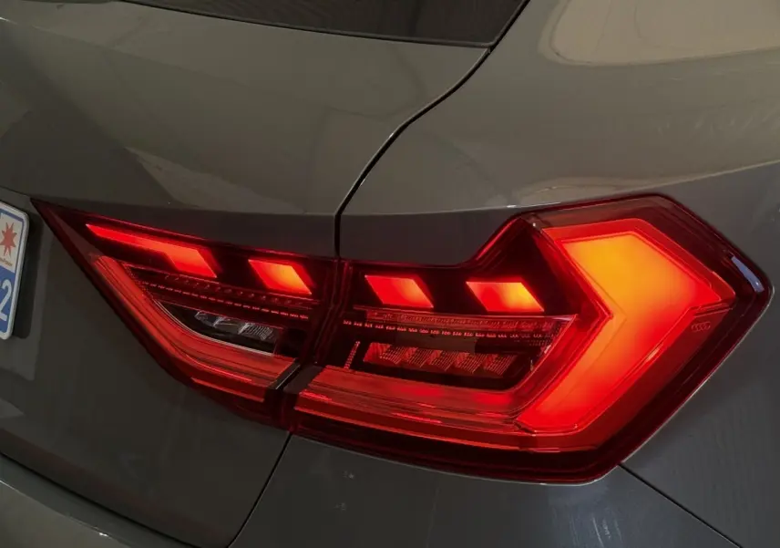 Feu arrière droit allumé d'une Audi A1 gris foncé 2020, mettant en valeur son design LED distinctif.