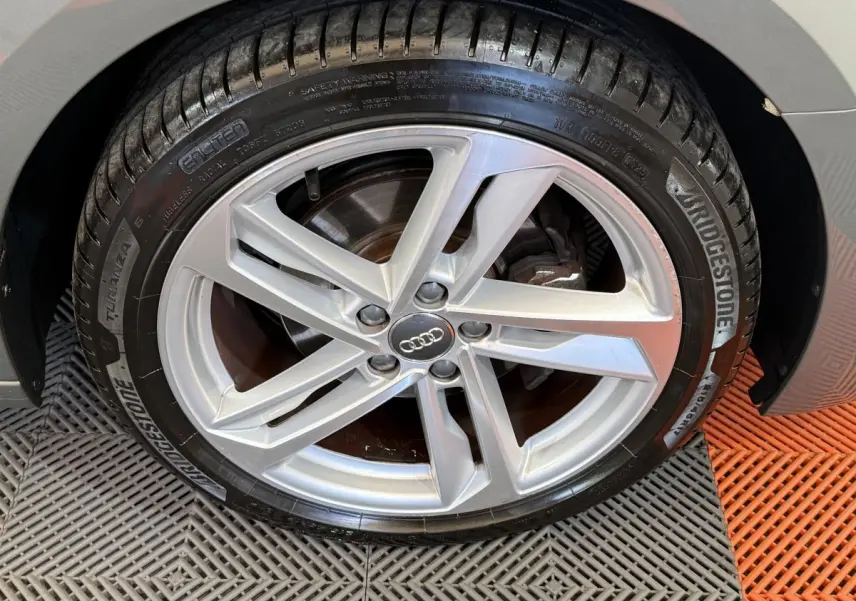 Gros plan sur la jante alliage argentée et pneu Bridgestone du côté arrière droit d'une Audi A1 gris foncé S line 2020.