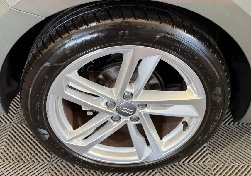 Gros plan sur la roue avant droite de l'Audi A1 gris foncé avec jante alliage à cinq branches doubles.