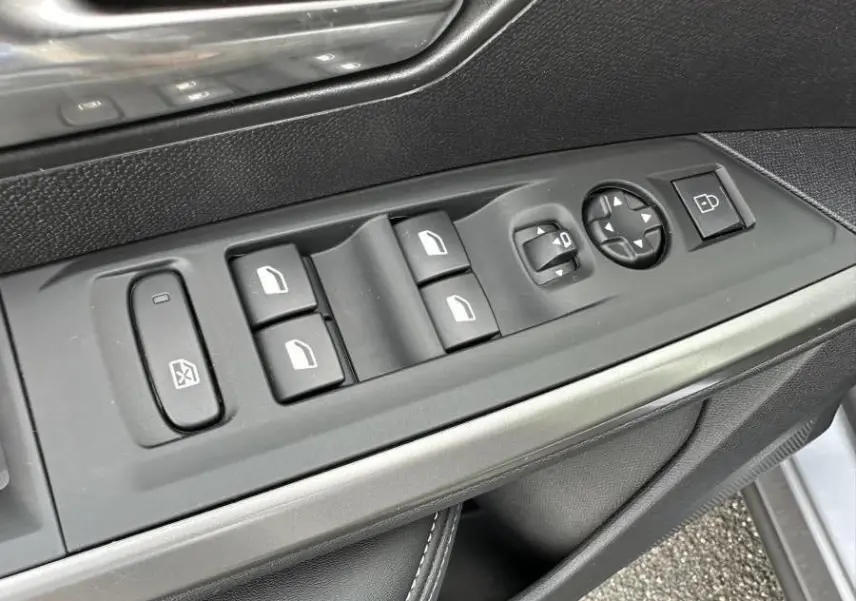 Gros plan sur les commandes des vitres et rétroviseurs côté conducteur du Peugeot 3008 2024 gris Artense.