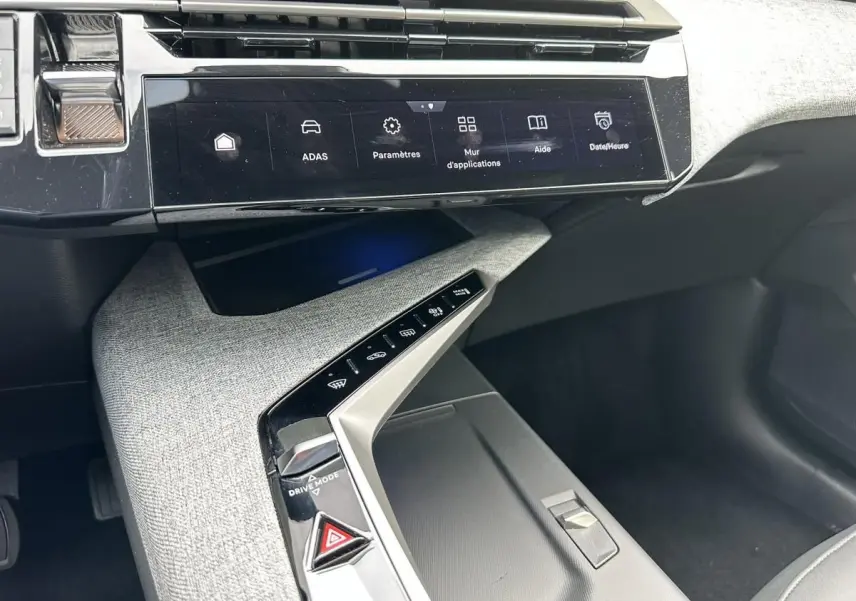 Vue rapprochée de la console centrale et écran tactile du Peugeot 3008 gris Artense, version hybride 2024.