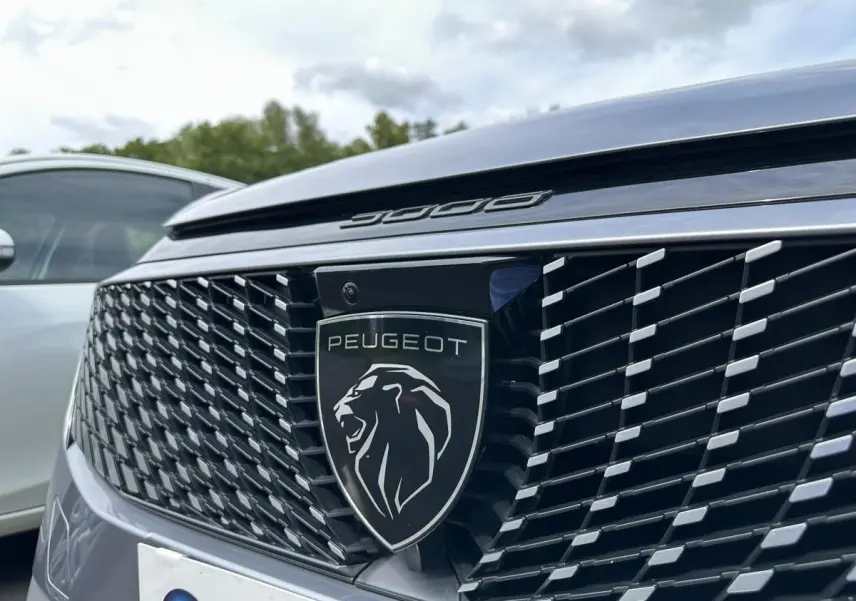 Gros plan sur la calandre avant gris Artense du Peugeot 3008 2024 avec logo lion et inscription 3008 au-dessus.