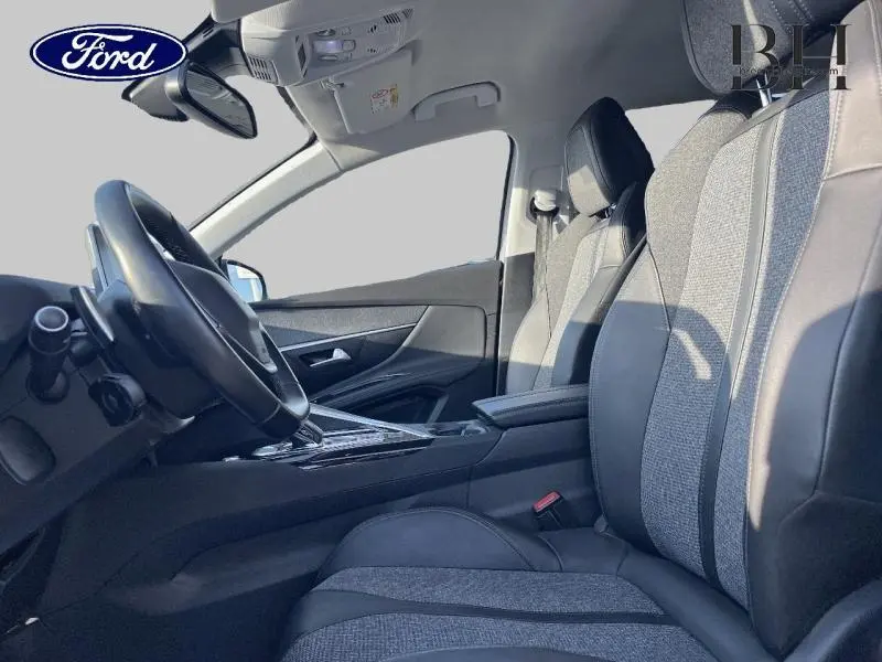 Vue intérieure côté conducteur du Peugeot 5008 2020, sièges tissu et cuir gris avec console centrale et volant multifonction.
