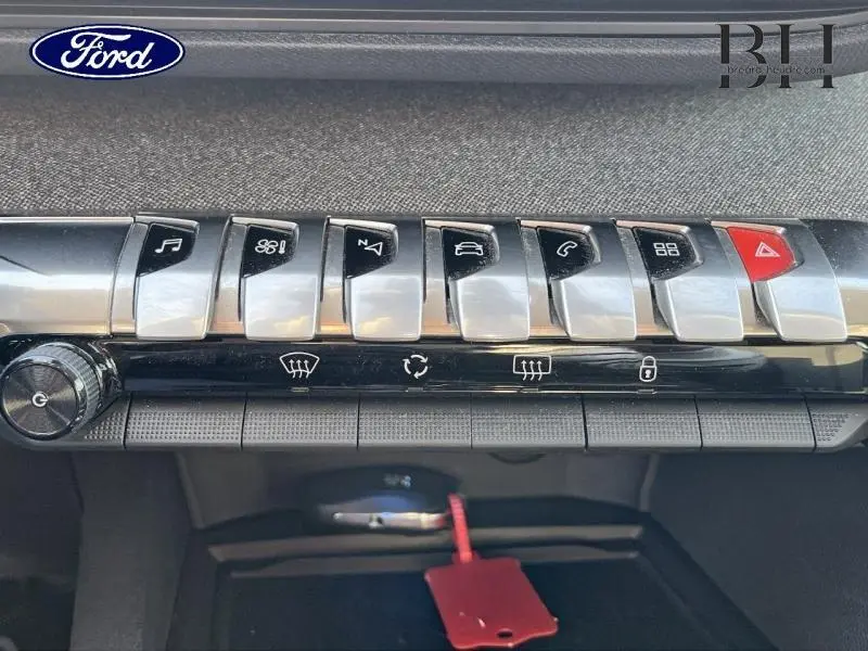 Détail des commandes centrales chromées et noires du tableau de bord d'un Peugeot 5008 gris Artense.