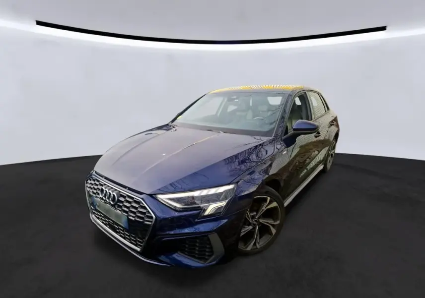 Audi A3 2.0 TDI S-Line bleu vue 3/4 avant droit dans un showroom avec mur en bois et enseigne lumineuse.