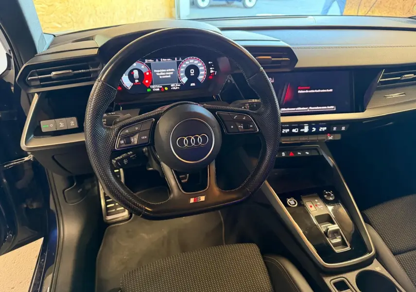 Intérieur noir de l'Audi A3 2.0 TDI 2022 vu du poste de conduite, avec volant S-Line et tableau de bord numérique.