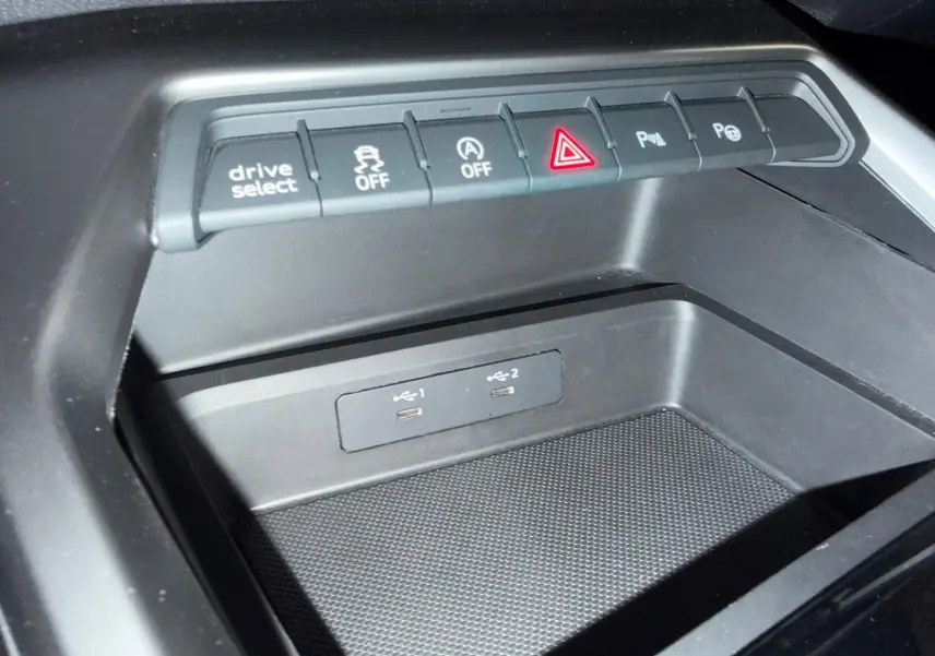 Gros plan sur la console centrale de l'Audi A3 2.0 TDI 150 S-TRONIC S-LINE, avec boutons de contrôle et ports USB visibles.