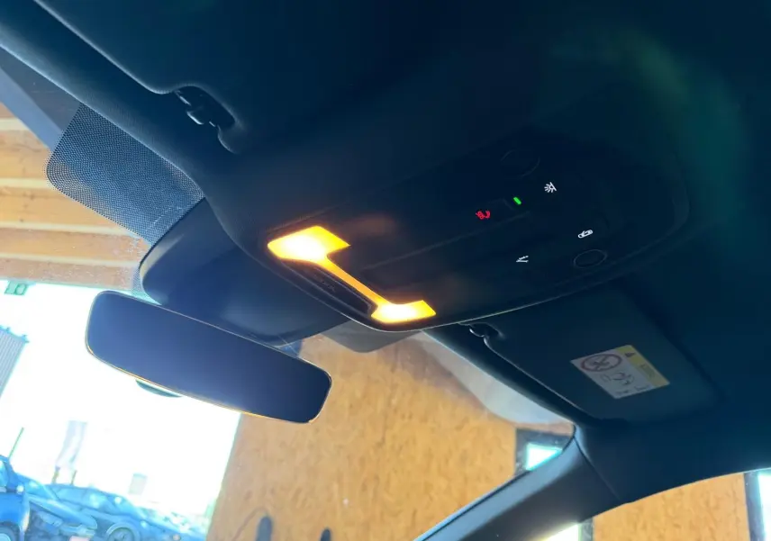 Vue intérieure du plafonnier et du rétroviseur central d'une Audi A3 bleu, avec éclairage allumé.