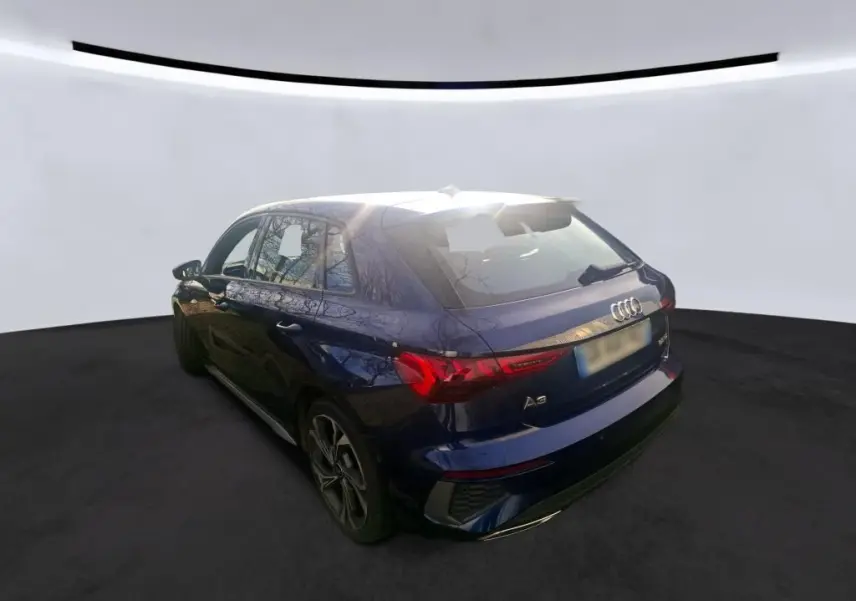 Vue frontale d'une Audi A3 2.0 TDI S-Line bleu foncé avec calandre hexagonale et logo Audi visible en intérieur.