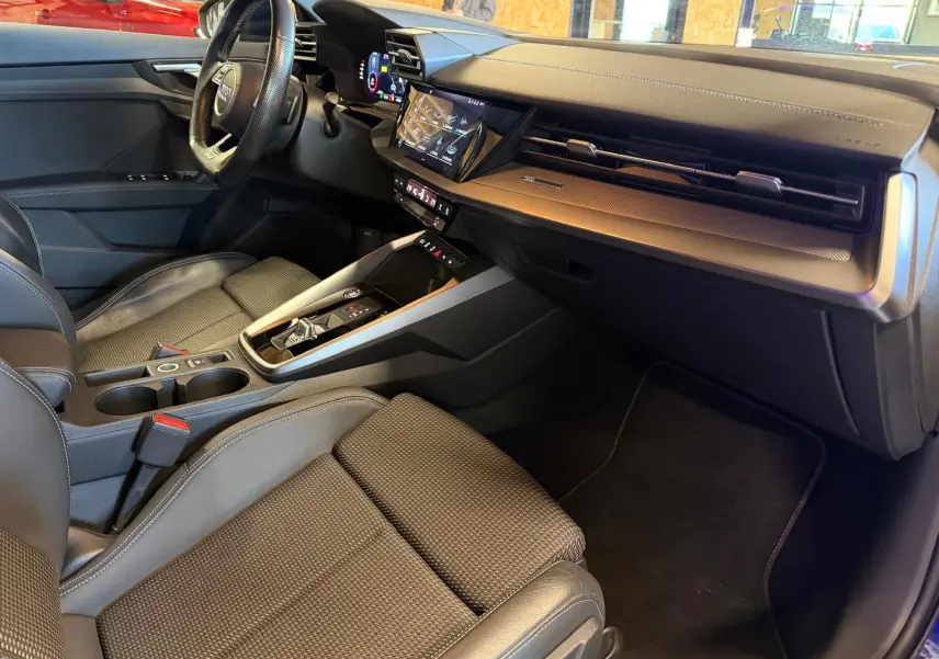 Intérieur noir de l'Audi A3 2.0 TDI 2022, vue côté passager montrant tableau de bord et console centrale moderne.