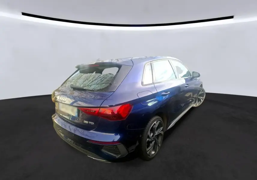Audi A3 2.0 TDI S-Line bleu vue de profil côté gauche, avec jantes alliage distinctives en intérieur bois.