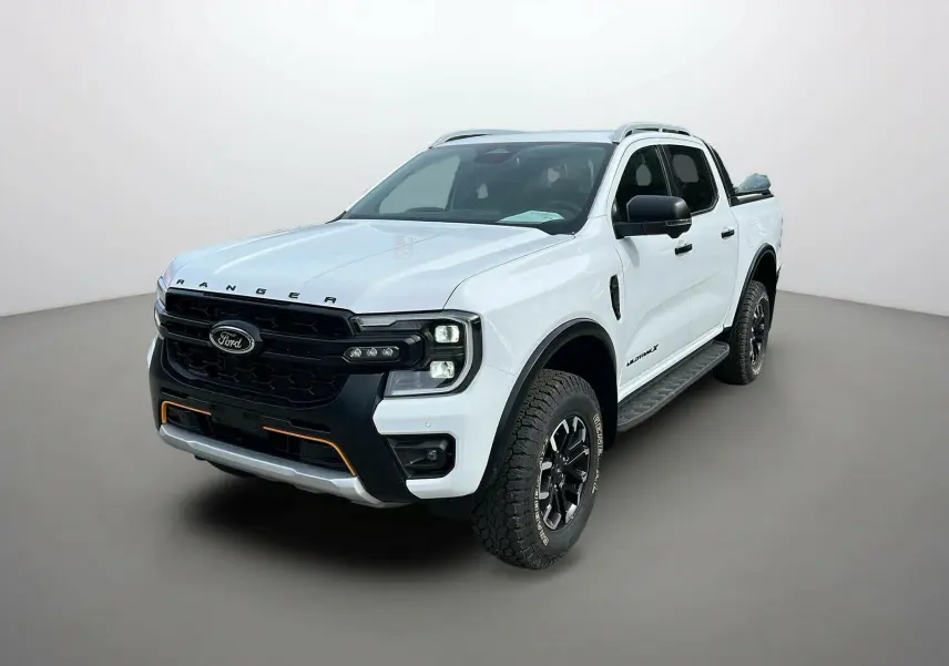 Ford Ranger 2025 blanc glacier en 3/4 avant droit avec calandre noire et détails orange sur pare-chocs.