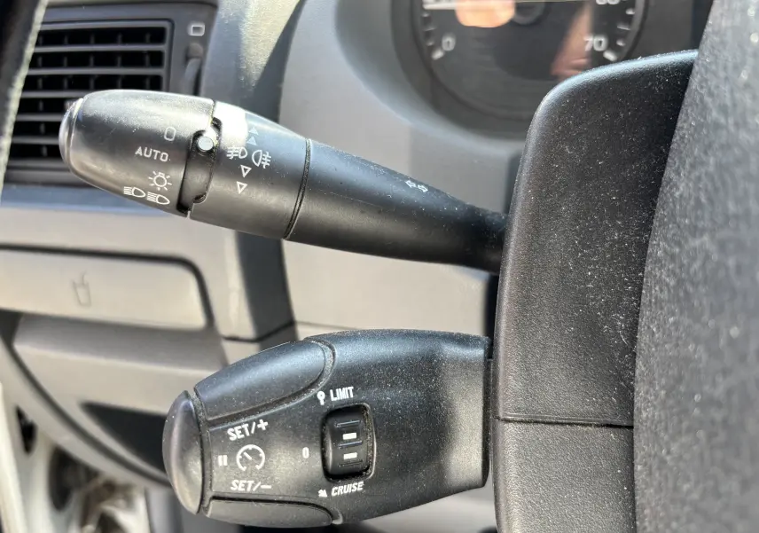 Gros plan sur les commandes de régulateur et feux du tableau de bord du Fiat Scudo Fourgon blanc de 2010.