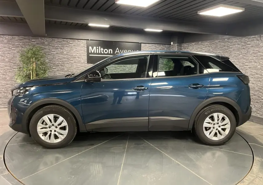 Profil côté gauche du Peugeot 3008 bleu métallisé 2022 avec jantes alliage et coques de rétroviseurs noires.