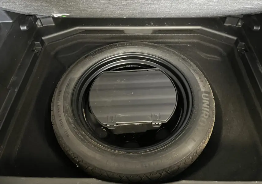 Gros plan sur la roue de secours type galette dans le coffre du Peugeot 3008 Diesel bleu 2022.