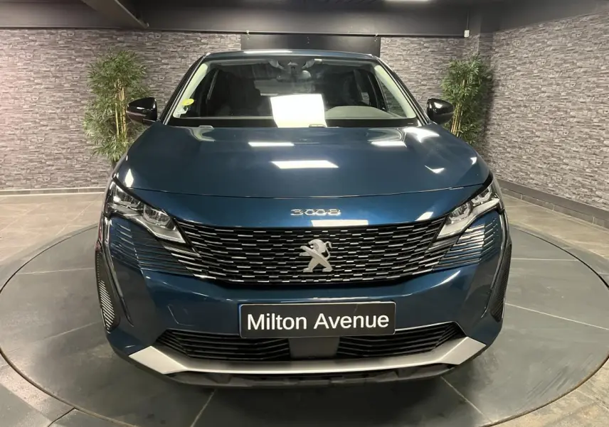 Vue avant d'un Peugeot 3008 bleu métallisé avec calandre à damier chromé et plaque Milton Avenue.