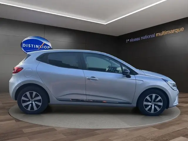 Profil côté droit de la Renault Clio V TCE 90 Evolution gris Highland avec vitres arrière surteintées en showroom