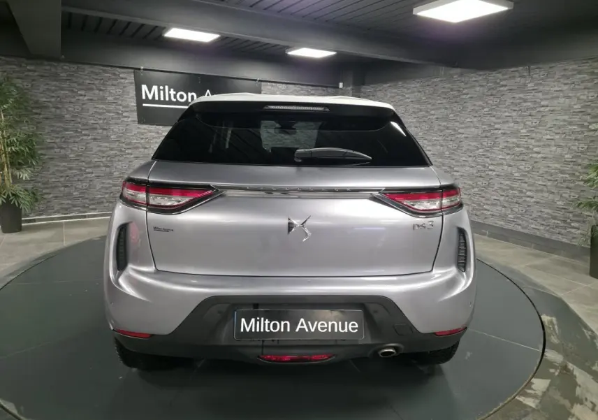 Vue arrière d'un DS3 Crossback gris métallisé avec feux arrière LED et canule d'échappement chromée visible.