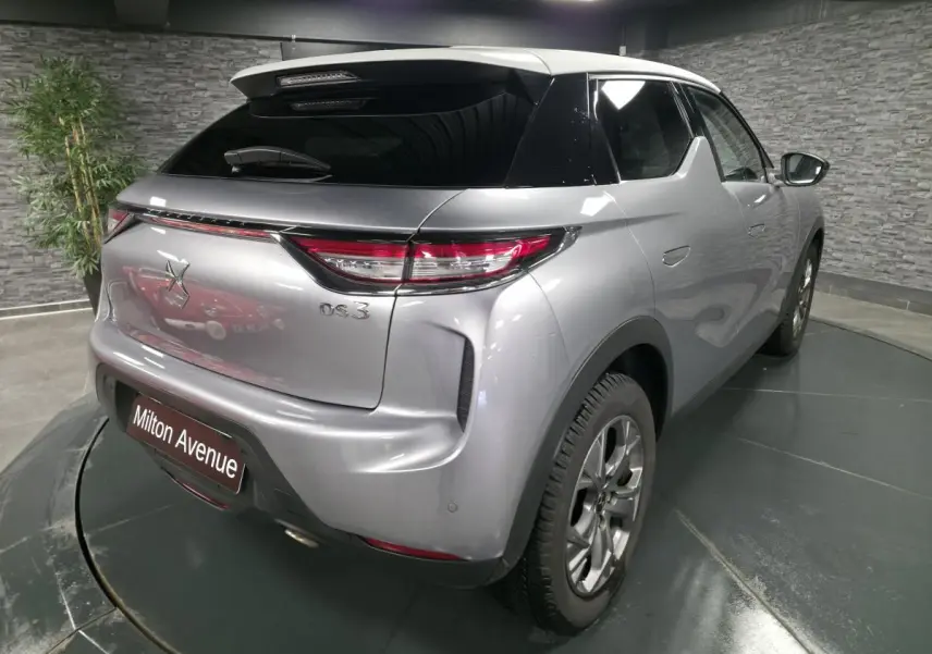 Vue 3/4 arrière droite d'un DS3 Crossback gris métallisé avec toit noir et feux arrière LED distinctifs.