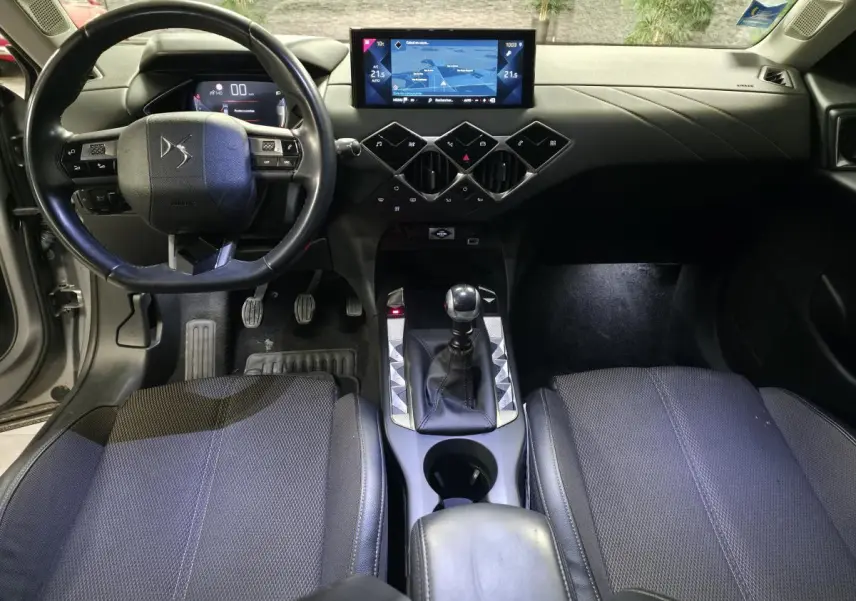 Vue intérieure avant du DS3 Crossback 2022 montrant le volant cuir, la console centrale avec levier de vitesses manuel et l'écran tactile.