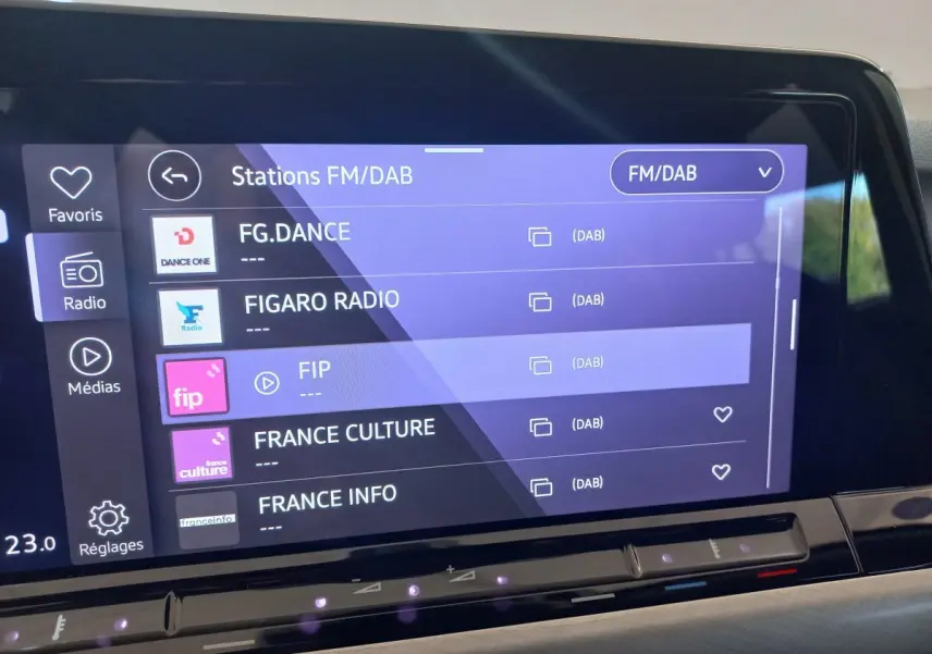 Écran tactile central de la Volkswagen Golf 1.5 bleu, affichant les stations radio FM/DAB en intérieur.