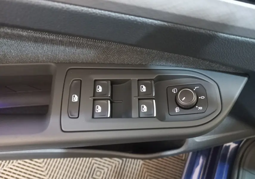 Vue rapprochée des commandes de lève-vitres et réglage des rétroviseurs côté conducteur d'une Volkswagen Golf bleu 2022