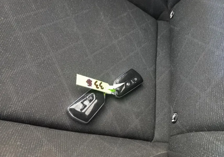 Clé de voiture Volkswagen Golf 2022 posée sur la banquette arrière en tissu gris foncé avec logo ISOFIX visible.