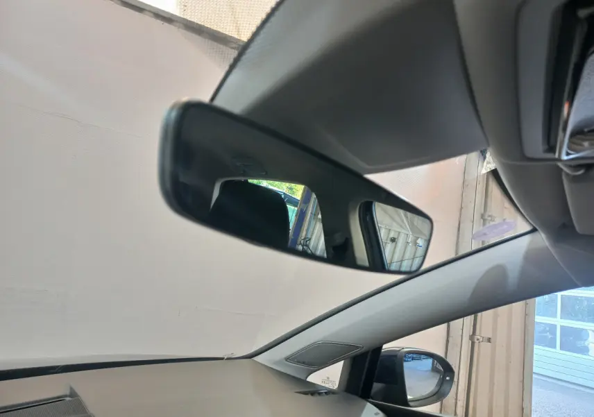 Vue intérieure côté gauche du rétroviseur intérieur et extérieur d'une Volkswagen Golf bleu 2022 stationnée en garage.