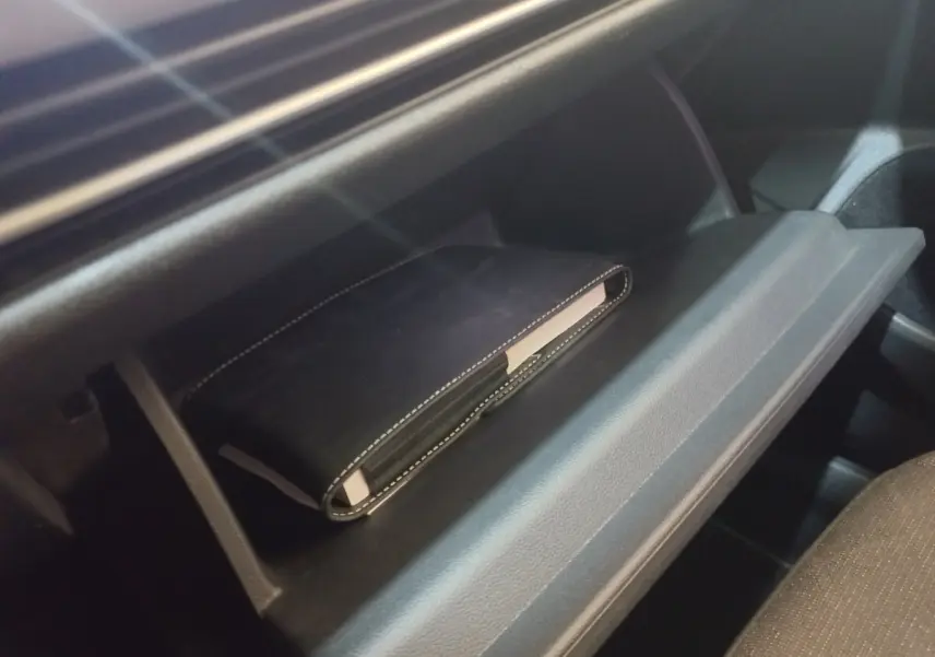 Gant de boîte à gants ouvert avec un carnet noir à l'intérieur, intérieur sombre de Volkswagen Golf 2022.