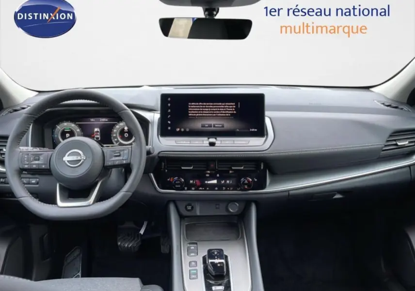 Vue frontale de l'intérieur du Nissan Qashqai gris 2025, avec tableau de bord numérique et écran tactile central.