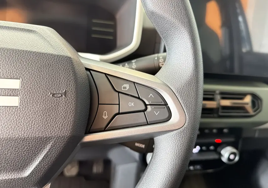 Gros plan sur le côté droit du volant du Dacia Spring 65 Extreme 2026, avec commandes multifonctions et tableau de bord partiel.