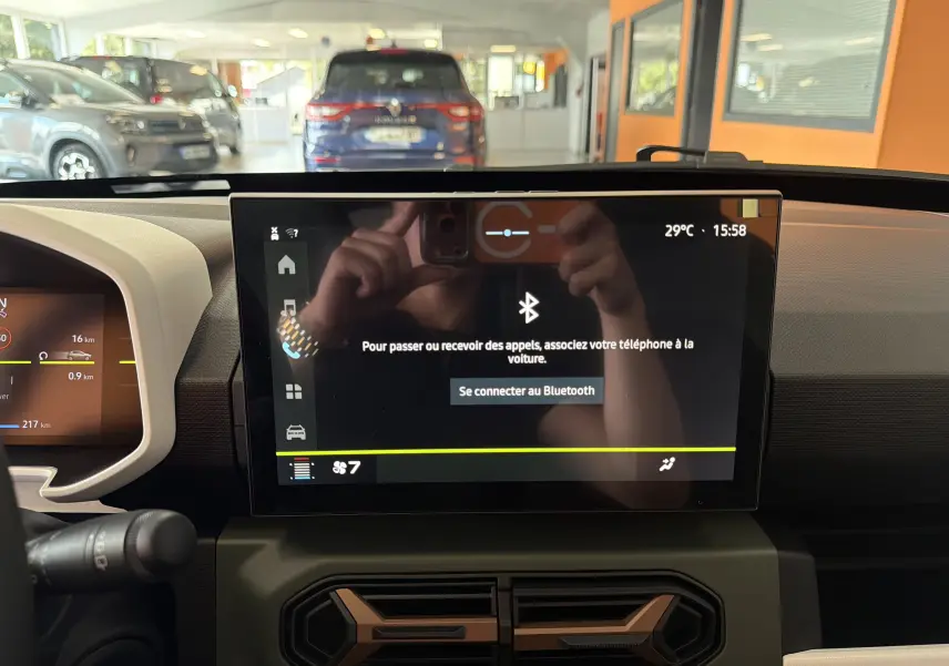 Intérieur du Dacia Spring 65 Extreme 2026, vue du tableau de bord avec écran tactile central allumé.