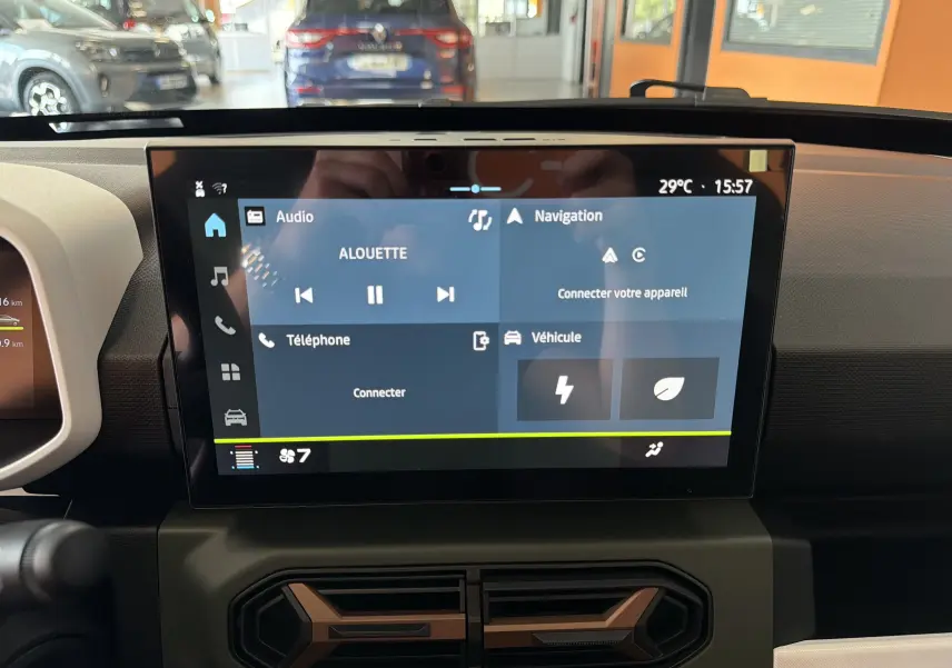Écran tactile central du tableau de bord du Dacia Spring 65 Extreme 2026, affichant les menus audio, navigation et véhicule.