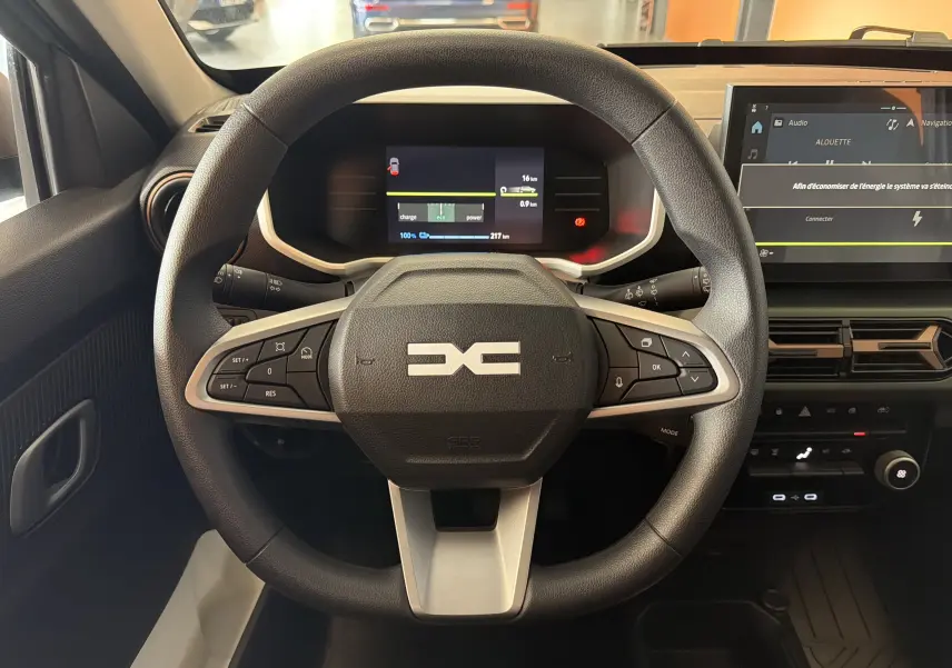 Vue centrée sur le volant du Dacia Spring 65 Extreme 2026, avec tableau de bord numérique et écran tactile.