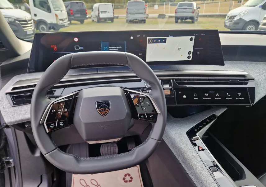 Vue intérieure du poste de conduite du Peugeot 3008 gris Artense 2025, avec volant cuir et écran panoramique tactile de 21 pouces.